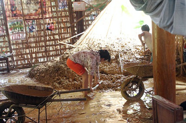 Người dân đang thu dọn những đống đất tràn vào nhà sau cơn mưa lớn kéo dài từ chiều tối 21/9 đến trưa 22/9.