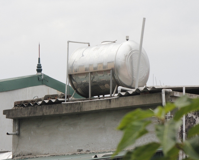 Téc nước được đặt trên giá đỡ mỏng manh phía trên mái nhà mà không có sự chằng chéo cố định nào.