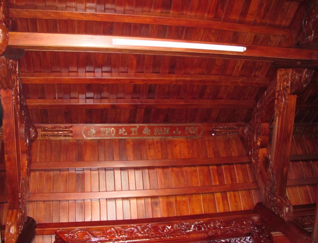 Phía trên mái nhà cũng được làm hoàn toàn bằng gỗ đinh hương với 2 dòng chữ lớn “Phúc như đông hải - Thọ tỉ Nam Sơn”.