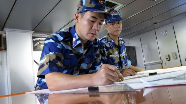 Cảnh sát biển Việt Nam trên tàu 8003 đánh dấu các vị trí tọa độ trên bản đồ. Ảnh: Martin Petty chụp ngày 15/7
