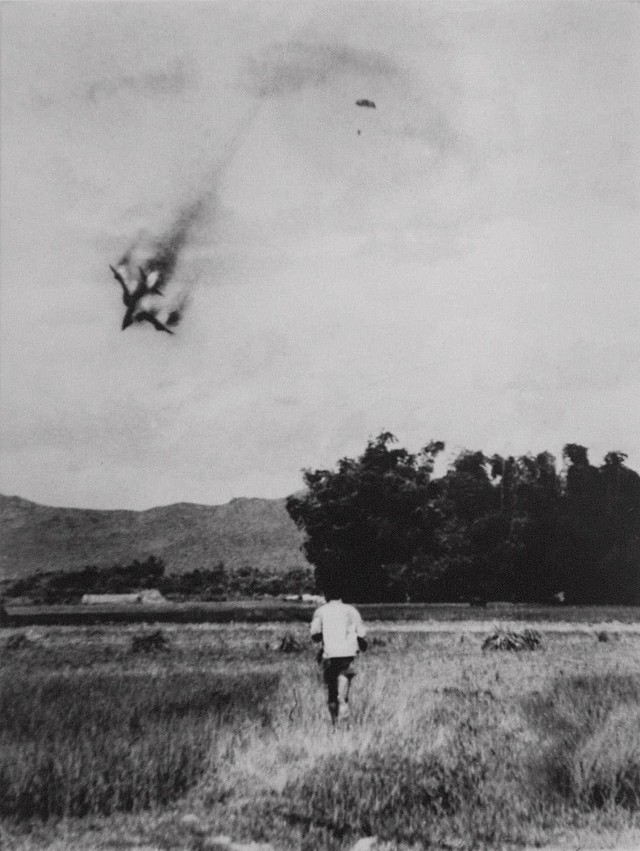 Một máy bay Mỹ, được cho là F-105, bị bắn rơi vào năm 1966 tại Việt Nam, có thể thấy dù của phi công ở hậu cảnh