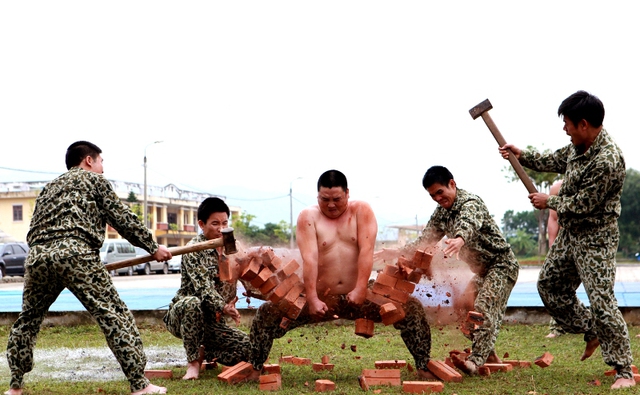 Dùng vai...và cánh tay kê gạch, “hứng” búa tạ.