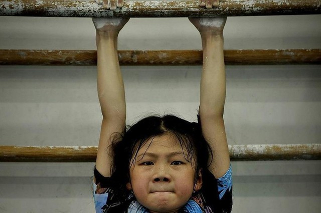 Thành phố Phúc Châu có phong trào trường học thể dục thể thao, cô bé 9 tuổi đang luyện tập treo mình trên xà, trong trường này có hàng trăm cô bé giống như cô. Theo quan niệm củaTrung Hoa thì muốn trở thành cường quốc thì thi đấu thể dục thể thao là con đường duy nhất. Ở Trung Quốc, các vận động viên đều được bồi dưỡng từ rất nhỏ, đa số đều trong 4-14 tuổi.