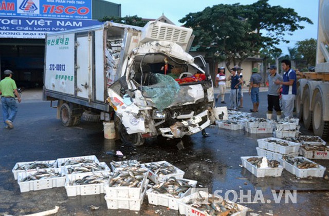 Đầu chiếc xe tải bị hư hỏng nặng, cá trên thùng văng tung tóe trên đường.