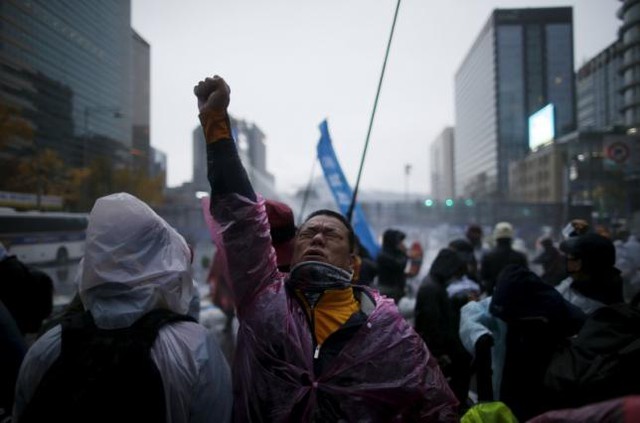 
Một người biểu tình phản ứng khi bị cảnh sát xịt nước và hơi cay bằng vòi rồng ở trung tâm thủ đô Seoul, Hàn Quốc hôm 14/11. Ảnh: REUTERS/KIM HONG-JI
