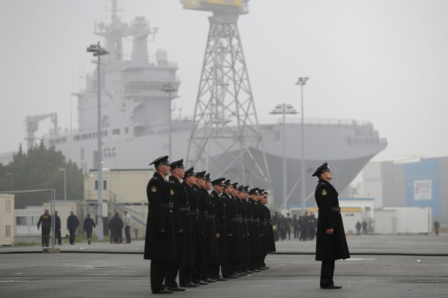 Russian sailors stand in formation in front of the Mistral-class helicopter carrier Vladivostok at the STX Les Chantiers de lAtlantique shipyard site in Saint-Nazaire