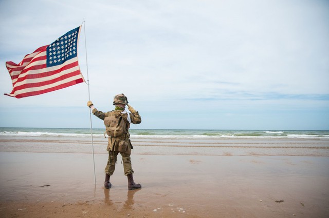 Một cậu bé người Pháp hóa trang thành lính Mỹ và đứng chào tại bãi biển Omaha trong suốt 2 giờ nhằm kỷ niệm 70 năm cuộc đổ bộ lên Normandy.