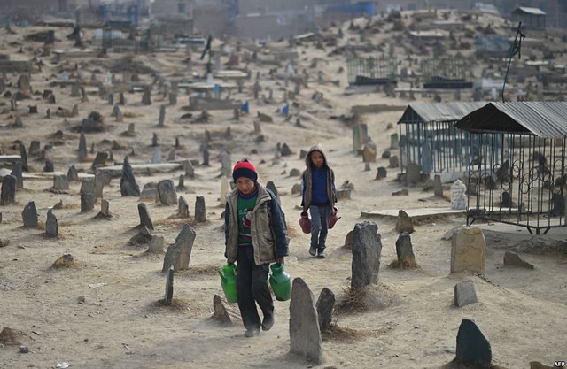 Trẻ em bán nước đang tìm khách mua tại nghĩa trang Kart-e-Sakhi ở Kabul, Afghanistan.