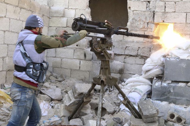 Chiến binh phiến quân Syria xả súng máy về phía quân đội chính phủ trong cuộc giao tranh tại thành phố Aleppo.