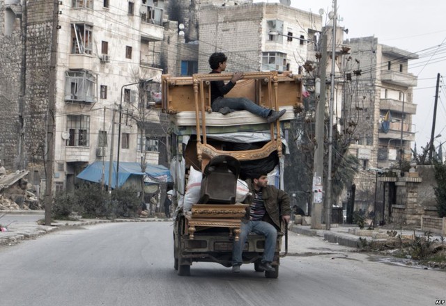 Người dân chở đồ đạc sơ tán khỏi khu vực giao tranh ở thành phố Aleppo, Syria.