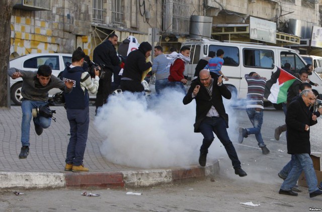Người biểu tình Palestine chạy tránh lựu đạn hơi cay do quân đội Israel bắn ra tại thành phố Hebron, Bờ Tây.
