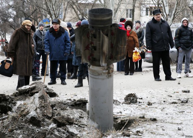 Mọi người nhìn xác một quả rocket găm xuống đường phố tại thị trấn Kramatorsk, miền đông Ukraine.