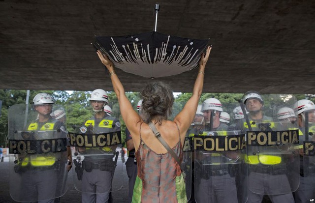 Người phụ nữ cầm chiếc ô lộn ngược trước hàng rào cảnh sát trong cuộc biểu tình phản đối chế độ phân phối nước ở thành phố Sao Paulo, Brazil.