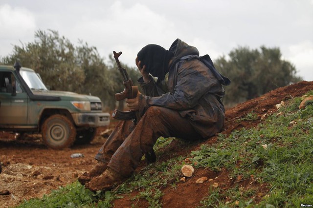 Chiến binh phiến quân Syria dính đầy bùn đất khi ngồi tại chiến tuyến ở ngôi làng Bashkuwi, thành phố Aleppo.