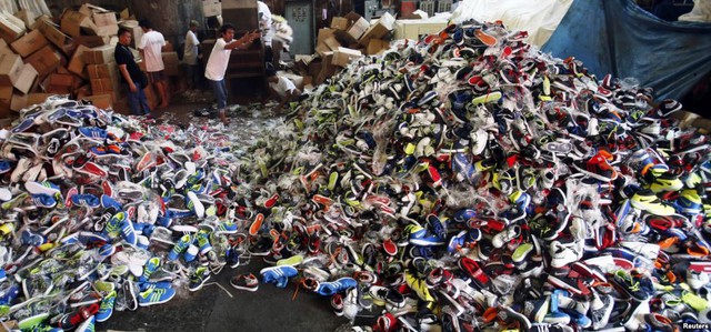Nhân viên hải quan tiêu hủy các sản phẩm giày nhái tại thành phố Manila, Philippines.