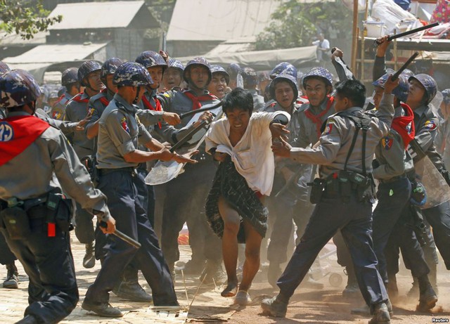 Cảnh sát chống bạo động dùng dùi cui đánh đập một sinh viên biểu tình tại Letpadan, Myanmar.