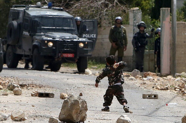 Một cậu bé 5 tuổi người Palestine ném đá vào cảnh sát Israel trong cuộc biểu tình ở Bờ Tây.