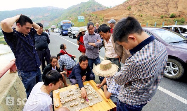 Không thể ngồi yên trên xe chờ đợi cho đến khi đường hết tắc, những người đàn ông này bỏ cờ tướng ra đánh ngay trên đường cao tốc