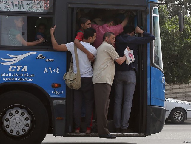 Hành khách chen nhau trên một chuyến xe bus quá tải ở ngoại ô thành phố Cairo, Ai Cập.