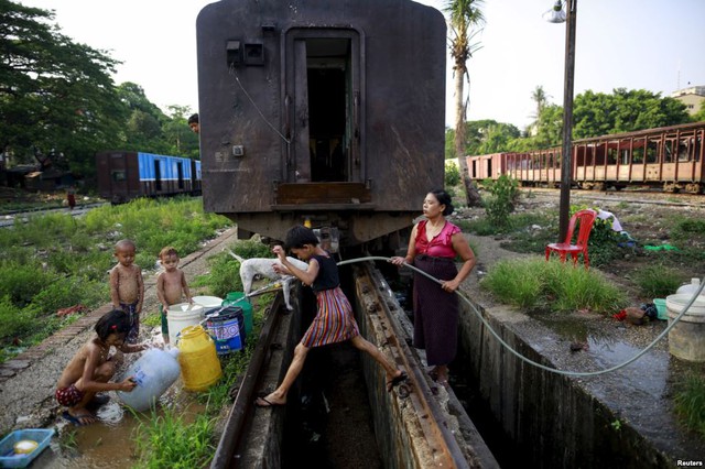 Trẻ em đùa nghịch khi mẹ của chúng đang lấy nước tại một ga tàu hỏa ở Yangon, Myanmar.
