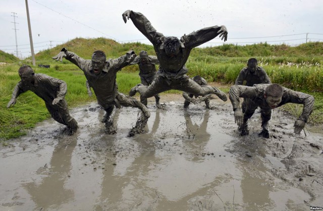 Cảnh sát bán quân sự Trung Quốc nhảy trên vũng bùn trong khi tập luyện tại một căn cứ quân sự ở thành phố Trừ Châu, tỉnh An Huy.
