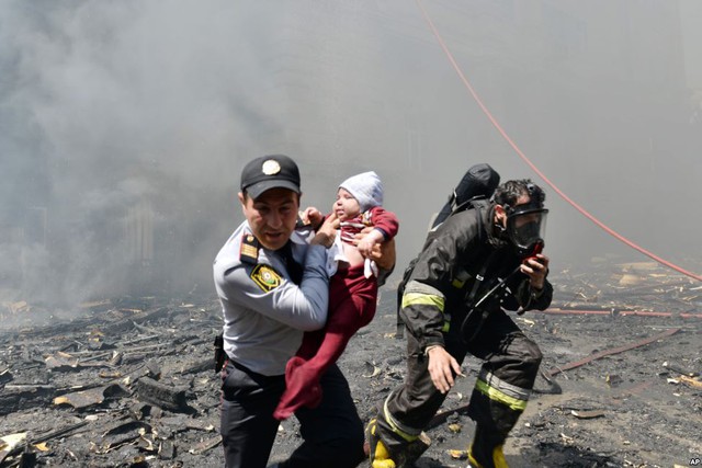 Cảnh sát và lính cứu hỏa giúp một nạn nhân trẻ em thoát khỏi tòa chung cư bị hỏa hoạn ở Baku, Azerbaijan. Vụ hỏa hoạn khiến ít nhất 16 người thiệt mạng và 50 người bị thương.