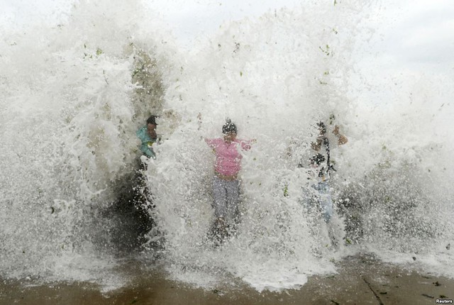Du khách mạo hiểm đùa giỡn với sóng do bão Chan-hom gây ra đập vào bờ biển tại thành phố Thanh Đảo, Trung Quốc.