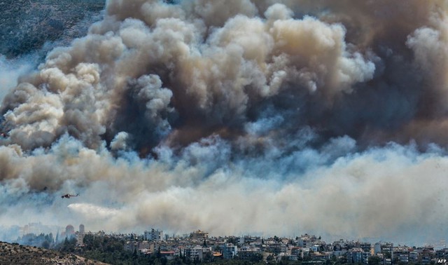 Máy bay trực thăng thả nước trong nỗ lực dập tắt cháy rừng ở ngoại ô thành phố Athens, Hi Lạp.
