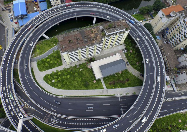 Tòa nhà chung cư cũ nằm thọt lỏm trong vòng tròn của đường cao tốc mới xây dựng tại thành phố Quảng Châu, Trung Quốc.