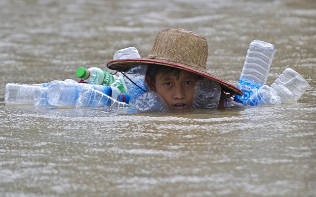 Cậu bé bơi trong nước lũ tại ngôi làng Kyaut Ye gần thị trấn Hinthada, Myanmar.