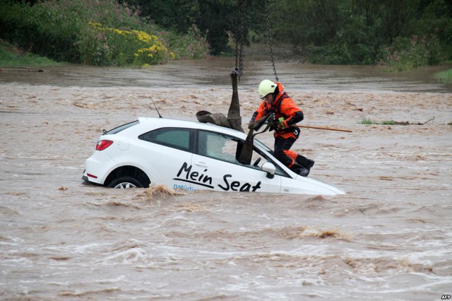 Nhân viên cứu hộ trợ giúp kéo một chiếc ô tô khỏi vùng nước ngập lụt ở Goettingen,  Đức.