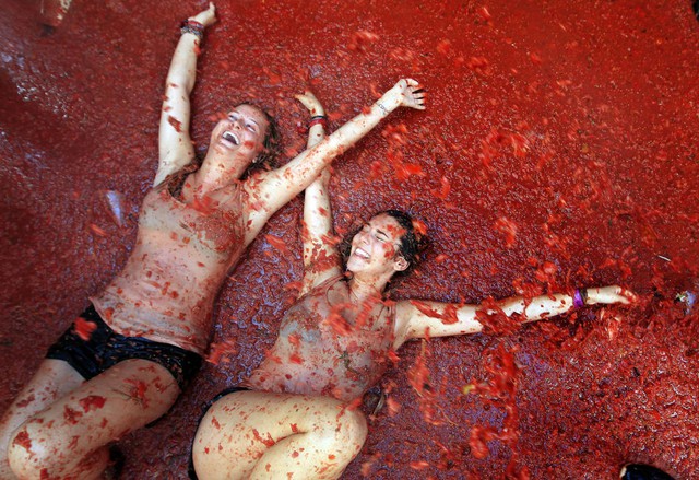 Hai cô gái nằm trong vũng nước cà chua trong lễ hội Tomatina được tổ chức hàng năm tại ngôi làng Bunol, Tây Ban Nha.