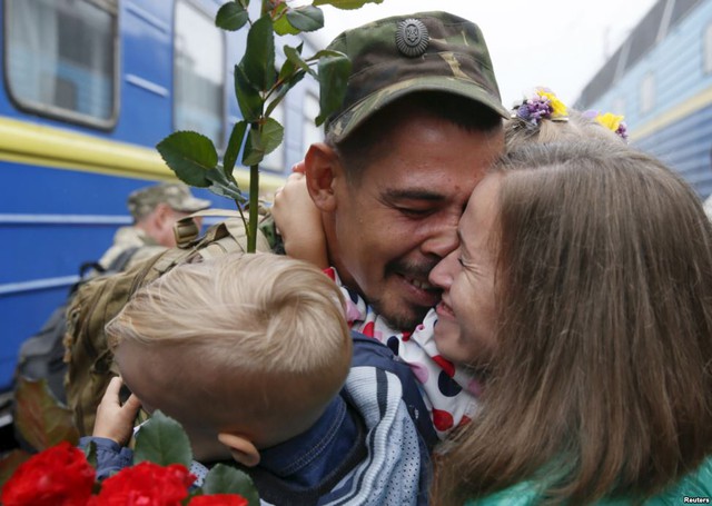 Quân nhân Ukraine ôm chặt vợ và con tại nhà ga tàu hỏa ở thủ đô Kiev, sau khi trở về từ chiến tuyến ở miền đông.