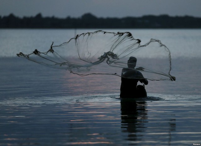 Ngư dân quăng lưới đánh cá dưới một hồ lớn ở thành phố Batticaloa, Sri Lanka.