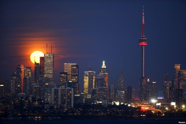 Khoảnh khắc Trăng tròn xuất hiện sau tòa tháp CN Tower và các tòa nhà chọc trời ở thành phố Toronto, Canada.