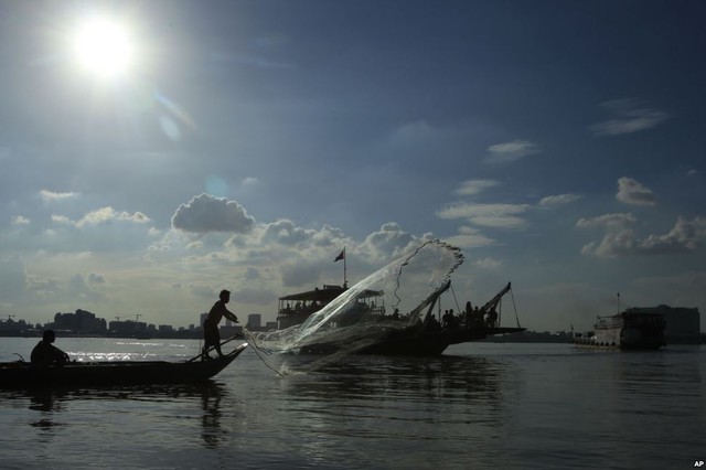 Ngư dân quăng chài đánh cá trên sông Mekong gần thành phố Phnom Penh, Campuchia.