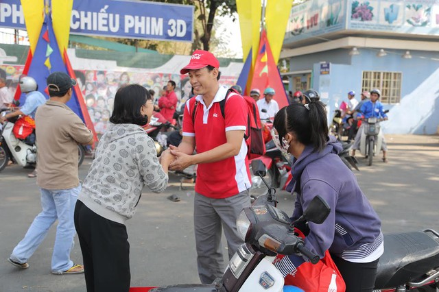 Một tình nguyện viên nắm tay và gửi lời chúc về một năm mới ấm no, tốt đẹp đến người dân tham gia “Vui Tết cùng Coca-Cola”. Đây là chương trình thường niên dành cho cộng đồng dân cư còn khó khăn đang sinh sống gần nhà máy Coca-Cola vào mỗi dịp Xuân về 