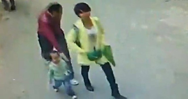 
Tại Tây An, Thiểm Tây, một người phụ nữ đi trước, theo sau là đứa trẻ trên đường đến trường. Khi quay lại, người phụ nữ phát hiện một người đàn ông chuẩn bị bế đứa trẻ chạy đi. (Nguồn: chinadaily)
