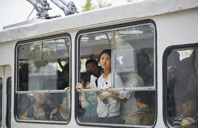 
 Trong hình là hình ảnh cô gái Triều Tiên đang nhìn ra ngoài cửa sổ trên một chiếc xe buýt chật chội. (Ảnh: Christian Petersen-Clausen)
