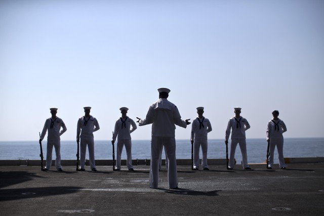 
Các thủy thủ trên tàu trong bộ đồng phục trắng chuẩn bị cho lễ tưởng niệm ngày 11/9.
