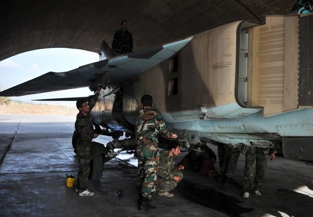 
Nhân viên kỹ thuật làm công tác chuẩn bị bay cho một chiếc Mig-23 của không quân Syria.

