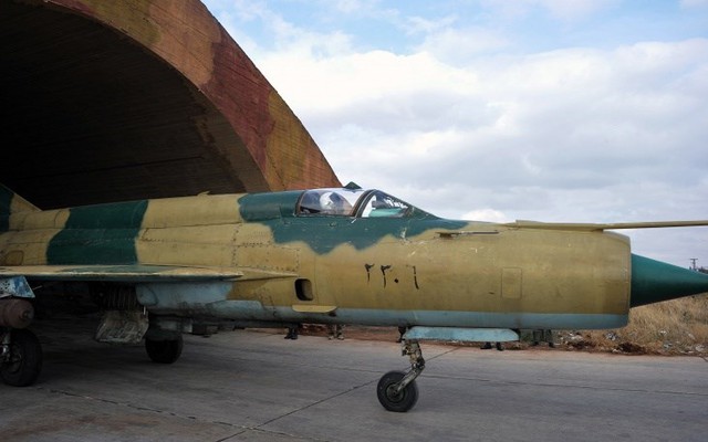
Được sản xuất nhiều nhất trong lịch sử hàng không quân sự; có thời gian sử dụng lâu nhất…đó là những “cái nhất” của Mig-21. Đây là loại máy bay có tốc độ siêu âm, tối đa đạt 2.500km/h. Trong ảnh: 1 chiếc Mig-21 của không quân Syria đang lăn ra khỏi vòm để máy bay.
