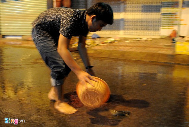 Tại khu vực ngã tư đường Tân Hoà Đông - Phan Anh (quận 6), anh Châu phát hiện thấy có cá bơi trên đường đã mang chiếc rổ nhựa ra bắt. Ảnh: Zing.vn