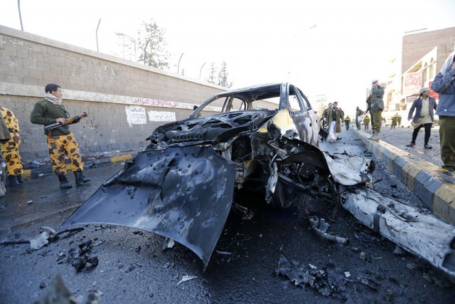 Cảnh sát đứng bảo vệ hiện trường vụ đánh bom tự sát bằng ô tô bên ngoài trường cảnh sát ở Sanaa, Yemen.