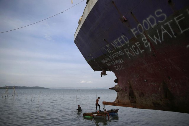 Các thợ lặn tham gia cứu hộ một tàu bị siêu bão Haiyan đánh vào bờ tại Tacloban, Philippines.