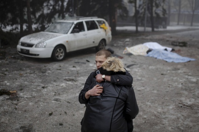 Một tay súng ly khai chấn an vợ của một dân thường thiệt mạng trong đợt pháo kích ở Donetsk, miền đông Ukraine.