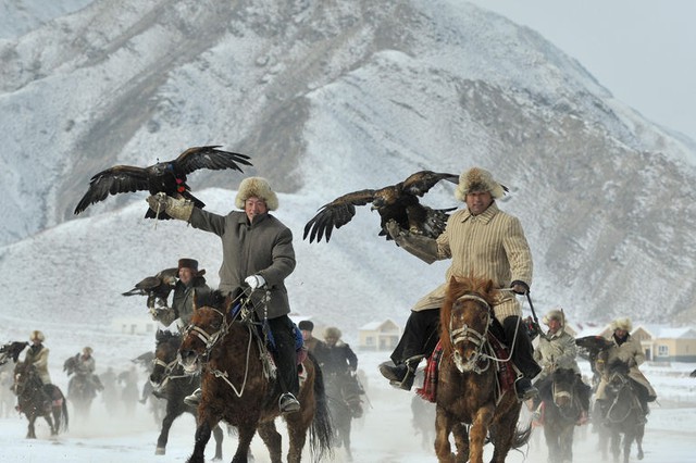 Những người chăn gia súc mang theo đại bàng khi cưỡi ngựa trong một cuộc thi săn ở Akqi, Kyrgyzstan.