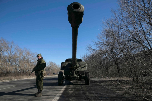 Một tay súng ly khai thân Nga đứng bảo vệ xe tăng tại Donetsk, Ukraine.