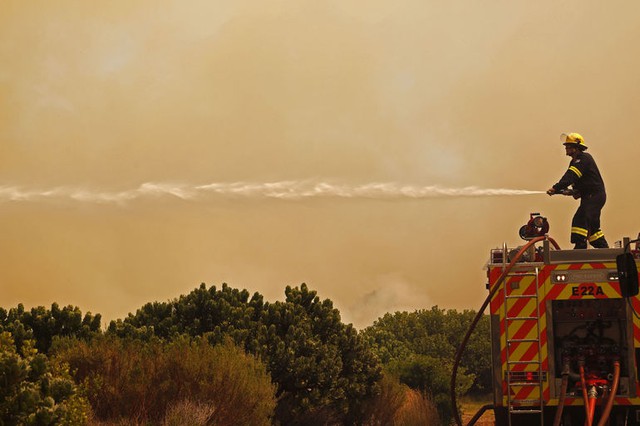 Lính cứu hỏa chiến đấu với cháy rừng gần thị trấn Hout Bay, Nam Phi.