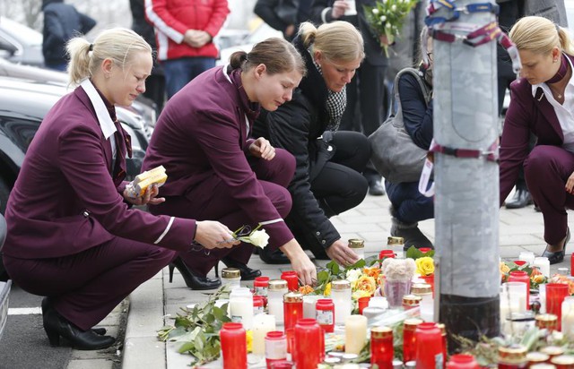 Nhân viên của hãng hàng không Germanwings khóc khi đặt hoa và thắp nến bên ngoài trụ sở hãng hàng không này tại sân bay Cologne Bonn, Đức, để cầu nguyện cho các nạn nhân thiệt mạng trong vụ máy bay Airbus 320  rơi.